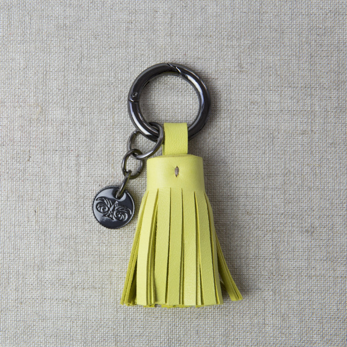 Key holder and bag charms TASSEL in lambskin anis color and shiny gun finishing - front view - linen background
