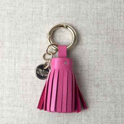 Key holder and bag charms TASSEL in lambskin, fuchsia color and gold - front view on linen background