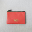 JULIE, zipper pouch in grained calfskin, red hibiscus color - front view on linen