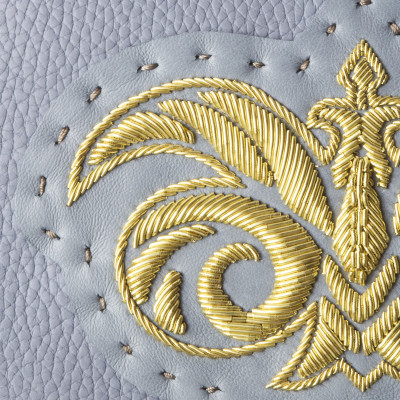 La pochette zippée en cuir "OSLO BRODÉE" coloris gris-lavande avec un logo or - broderie cannetille