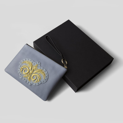 La pochette zippée en cuir "OSLO BRODÉE" coloris noir avec un logo noir vintage - face