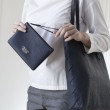 SUZY, lambskin zipper pouch, navy blue color with black leather wrist strap - on model