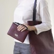 SUZY, lambskin zipper pouch, burgundy color with black leather wrist strap - on model