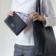 SUZY, black lambskin zipper pouch with leather wrist strap - on model